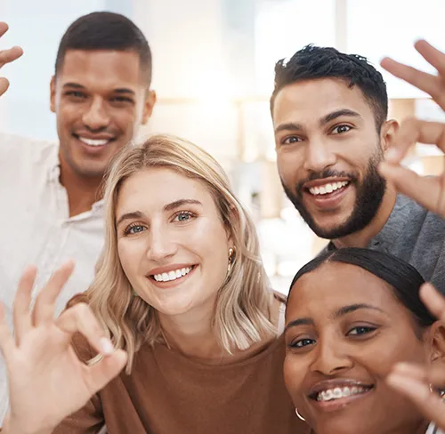 People smiling, giving 'ok' hand gesture.